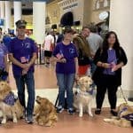 Group with service dogs in indoor setting.