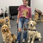 Woman with two service dogs indoors.